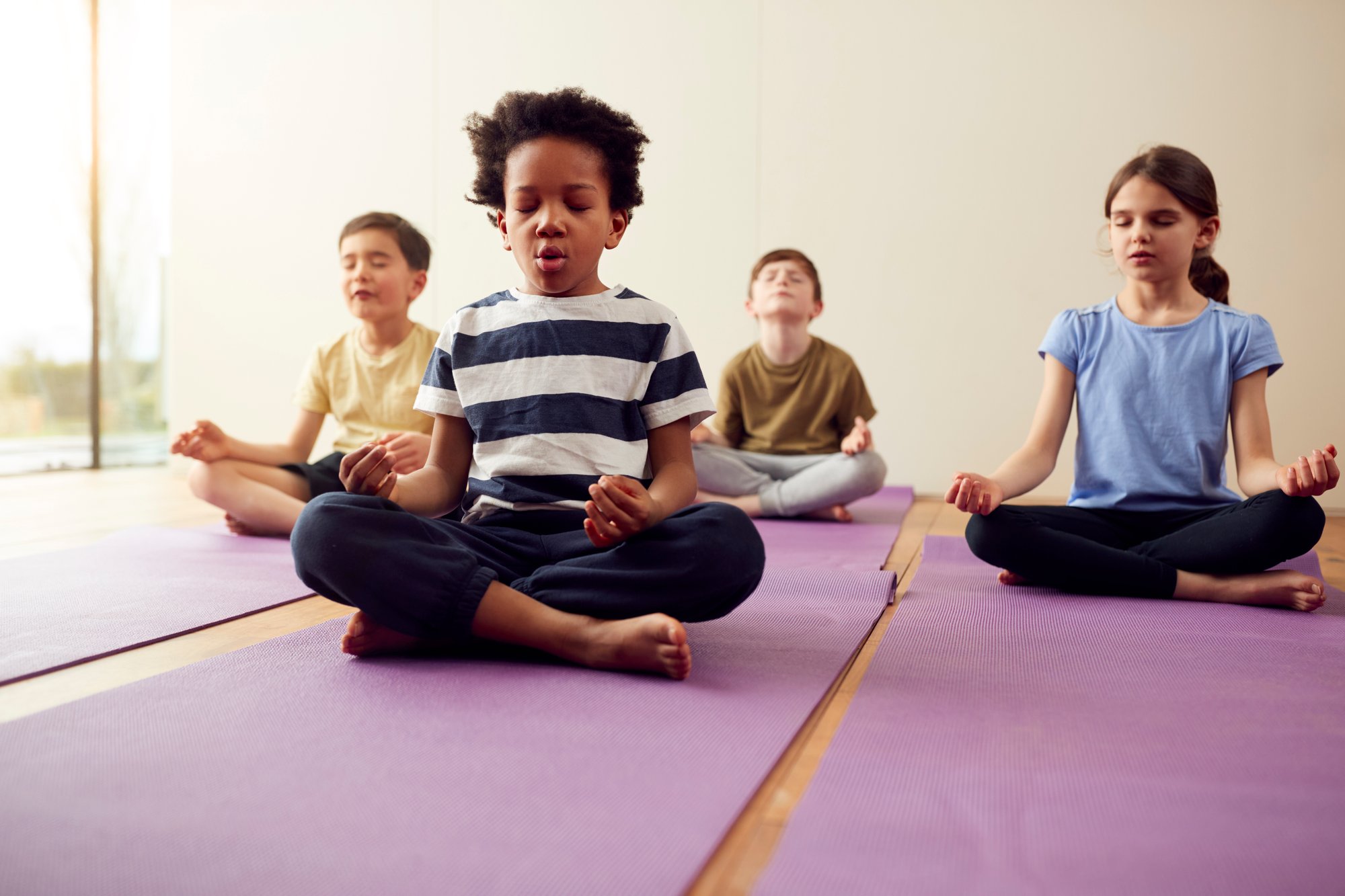 group-children-sitting-exercise-mats-meditating-yoga-studio
